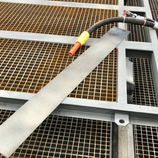 Haaveldamise seade musta voolikuga metallribal terasrestist tööstuspõrandal