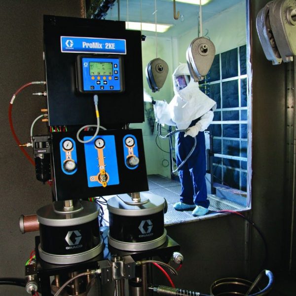 Graco ProMix 2KE värvisegamissüsteem ja operaator kaitseülikonnas värvimiskabiinis